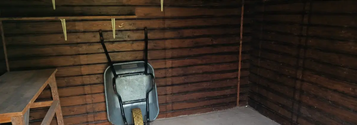Après le débarras : l’abri vide, sol dégagé, une brouette rangée au mur